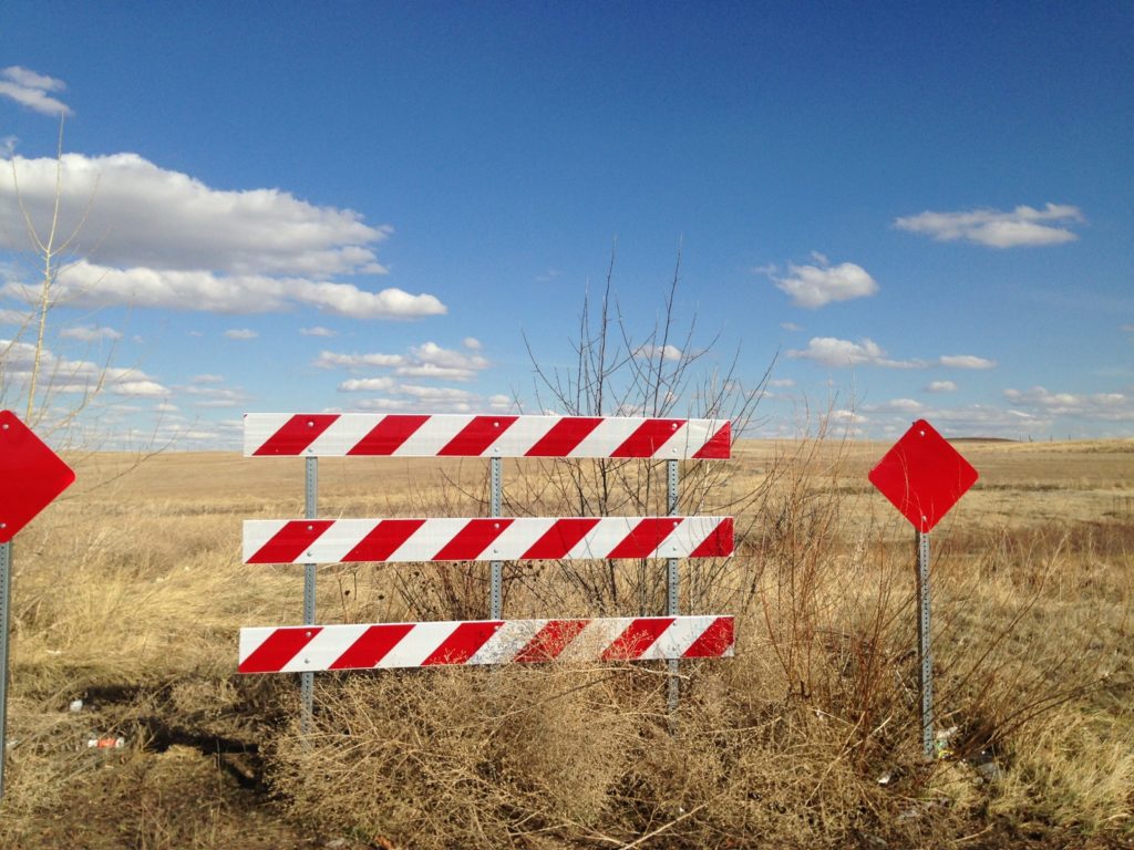 red and white road-closed barrier