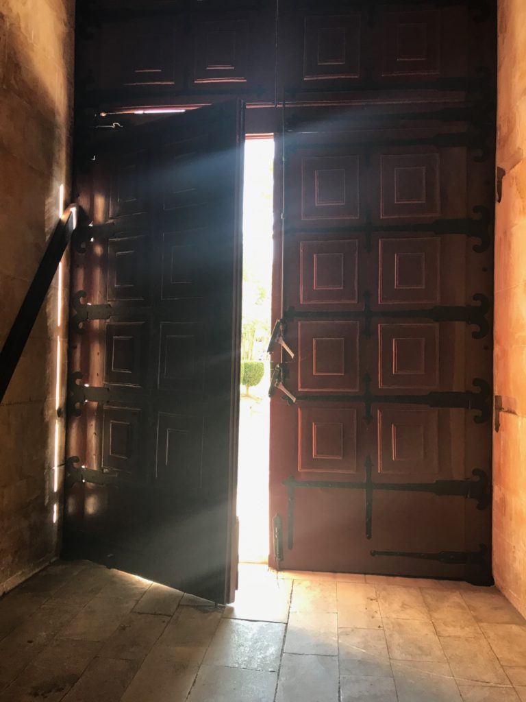 heavy door ajar with light streaming in