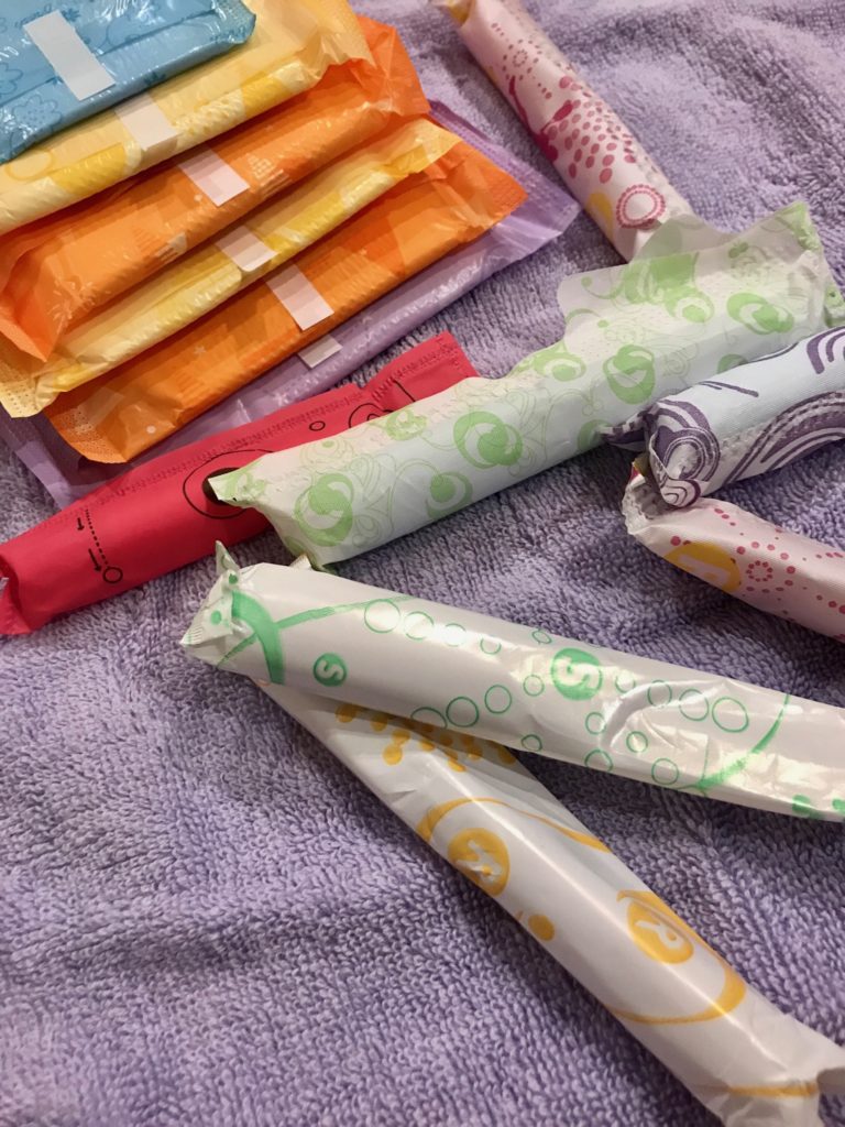 tampons and sanitary pads in colorful packaging